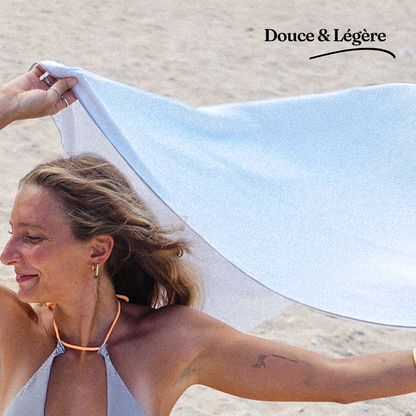 Fille qui étend une serviette magnetique microfibre magnette prenant le vent - microfibre légére douce compacte